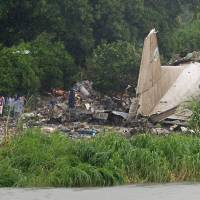 People gather at the site where a cargo plane crashed into a small farming community on a small island in the White Nile river, close to Juba airport in the Hai Gabat residential area, on Wednesday. Overloading suspected as aging cargo plane crashes near Juba; 36 confirmed dead