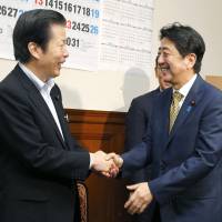 Prime Minister Shinzo Abe shakes hands with Komeito chief Natsuo Yamaguchi at the Diet in September after Abe won another term as president of the Liberal Democratic Party. Komeito an essential election partner for LDP