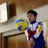 A 13-year-old Japanese-born son of Vietnamese refugees practices volleyball during the Asia Sports Festa in Yokohama on Oct. 25. Japan's tiny refugee community urges Tokyo to open doors wider