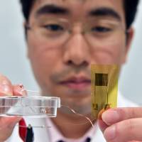 University of Tokyo researcher Tomoyuki Yokota displays a micro-thin thermal sensor that can be attached directly to the skin and measure temperatures. Sensor discovery more than skin-deep