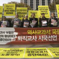 A matter of history: Retired South Korean teachers shout slogans during a rally against the revision of the publication system for Korean history textbooks in front of the government complex in Seoul last week. South Korea's new state textbook 'corrects' history