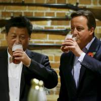 Down one for diplomacy: Chinese President Xi Jinping (left) drinks a beer with British Prime Minister David Cameron at a pub in England last month. Chinese media crucial in public diplomacy effort
