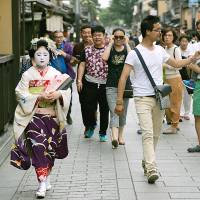 Tourists look on as a maiko — an apprentice geisha —walks past in the Gion area of Kyoto. From 'samurai' to 'Hello Kitty,' search data show how the world's view of Japan has changed