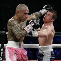 Miguel Cotto (left) and Canelo Alvarez trade punches during their title fight in Las Vegas on Sunday. Alvarez, Golovkin on collision course