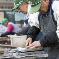 At the sharp end: Retirees sharpen knives as part of the Silver Jinzai Service in Tokyo on Dec. 15. Growing old, gracefully: senior citizens in the workplace