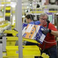 Mark Oldenburg processes outgoing orders Monday at Amazon.com's fulfillment center in DuPont, Washington. Shoppers spent more than $3 billion online this Cyber Monday, making it the biggest online shopping day ever. Cyber Monday online shopping spree tops $3 billion