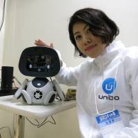 A Unirobot Corp. worker displays the company's Unibo toy during the International Robot Exhibition 2015 in Tokyo's Koto Ward on Wednesday. International robot show powers up in Tokyo
