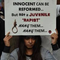 An Indian protester holds a placard during a demonstration against the release of a juvenile rapist in New Delhi on Monday. India’s Supreme Court rejected an appeal against the release of the youngest convict in an infamous fatal gang-rape, sparking fury from the victim’s parents who said the ruling was a betrayal of women. India court condemns seven for raping, murdering, mutilating mentally ill Nepali woman