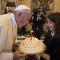 Pope Francis blows out a candle on a cake during a special audience with members of Italian Catholic Action movement at the Vatican on his 79th birthday Thursday. Ever-popular to masses pope turns 79 amid Vatican conservative climate of intrigue