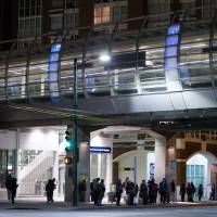 People stand outside the Main Street Skytrain station after the commuter train system was shut down to check for any possible damage to elevated guideways in Vancouver, British Columbia, early Wednesday after an earthquake struck off the western coast late Tuesday night. M4.8 Canada quake felt across Washington state