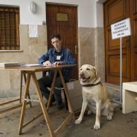 Hector Benitez, 38, who has been blind since the age of 26, reads his braille ballot in Palma de Mallorca on Sunday ahead of casting his ballot for Spain's general election. Spaniards vote in landmark election that could end two-party politics