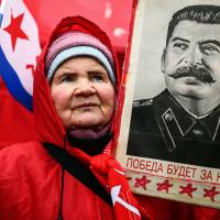 A Russian holds up a portrait of former Soviet dictator Josef Stalin during a rally in Moscow in February, 2014. Russia opens new Stalin museums, grapples with terror legacy