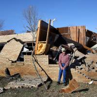 J.W. Skelton sits on what was a wall to Calvary Baptist Church in Ashland, Mississippi, Thursday. At least 11 people were killed in as spring-like storms mixed with unseasonably warm weather spawned rare Christmastime tornadoes in the U.S. South, officials said Thursday. At least 10 killed, including boy in wind-tossed car, as Christmas twisters tear through U.S. South