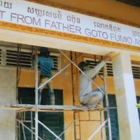 Workers repair a school in Cambodia built by AMATAK. Priest's aid effort provide education in rural Cambodia