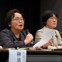 Plaintiffs contesting a spouse name rule address reporters in Tokyo on Wednesday. Plaintiffs express shock at bad precedent set by court's decision on shared surnames