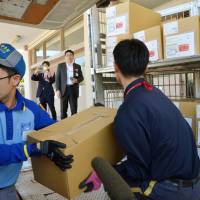 Postal workers move boxes containing My Number notification mail at a post office in Ishikawa Prefecture in October. The mail-outs have yet to be delivered to 24 percent of households across the country as of the end of last month, according to Japan Post Co. My Number ID notices yet to reach 24% of Japan households