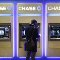 A customer uses an ATM at a branch of Chase Bank on Jan. 14 in New York. JPMorgan Chase will roll out later in 2016 new ATMs that will allow customers to access the machine or withdraw cash using their cellphone, the company said Monday. Chase readying debut of card-free, cellphone app-linked ATMs