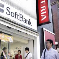 Pedestrians walk past the entrance to a SoftBank store in Tokyo in September. SoftBank to offer lower price option for smartphone users