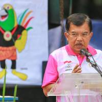 An image of the 2018 Asian Games mascot is displayed as Indonesian Vice President Jusuf Kalla delivers a speech Dec. 27. Online flap forces review of Asian Games mascot