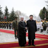 Chinese President Xi Jinping shakes hands with Iranian President Hassan Rouhani as they pose for a photograph in an official arrival ceremony at the Saadabad Palace in Tehran on Saturday. Iran, China vow tighter ties as Xi visits