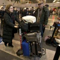 French journalist Ursula Gauthier, a reporter in China for the French news magazine L'Obs, pushes her luggage through Bejing Capital International Airport in Beijing on Thursday followed by a plainclothes security officer. Gauthier is leaving China after being denied press credentials and facing heavy criticism from the Foreign Ministry and state media over her reporting, becoming the first foreign journalist forced to leave China since 2012, when American Melissa Chan, then working for Al Jazeera in Beijing, was expelled. Media in China face dark, 'dangerous' days, says expelled French journalist who covered Uighur issues