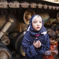 A girl attends Friday prayers on Feb. 18, 2011, in front of an army tank during the protests in Cairo's Tahrir Square. Five years after Egyptian uprising, crisis remains but hopes are gone
