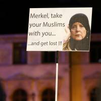 Members of LEGIDA, the Leipzig arm of the anti-Islam movement Patriotic Europeans Against the Islamisation of the West (PEGIDA), hold a poster depicting German Chancellor Angela Merkel during a rally in Leipzig, Germany, Monday. Merkel facing pressure as German gangs target foreigners after Dec. 31 assaults blamed on migrants
