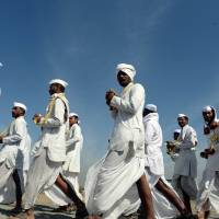 Indian Hindu pilgrims who follow a religious movement within the spiritual tradition of Hinduism sing songs as they arrive to take part in a right-wing Rashtriya Swayamsevak Sangh (RSS) rally in Pune on Sunday. Over 150,000 RSS volunteers attended the event, which was the largest in recent years. Over 150,000 Hindu nationalists gather for massive India rally