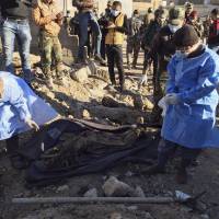 Iraqi forensic team members work at the site of a mass grave believed to contain the bodies of Iraqi civilians killed by Islamic State group militants in Ramadi, 115 km (70 miles) west of Baghdad Monday. Iraqi forces find over 40 dead women, children, police in Ramadi mass grave