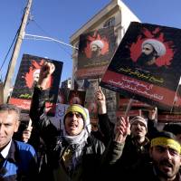 Iranian protesters chant slogans as they hold pictures of Shiite cleric Sheikh Nimr al-Nimr during a demonstration against the execution of Nimr in Saudi Arabia, outside the Saudi Arabian Embassy in Tehran Sunday. Saudis sever Iran ties as tensions soar after Shiite cleric's execution
