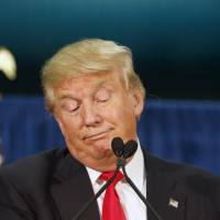 U.S. Republican presidential candidate Donald Trump stops speaking while waiting for protesters to be removed at a campaign rally at the University of Iowa in Iowa City, Iowa, Tuesday. Trump's otter's tail, ear of corn, abstract art 'egg yolk' locks stump stylists