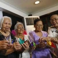 Richelda Extremadura (right) executive director of Lila Pilipina, or the League of Filipino Women, an organization of former “comfort women” and their supporters, assists Filipino victims at a forum Friday in suburban Quezon City, northeast of Manila. The event was held ahead of this week’s five-day state visit to the Philippines by Emperor Akihito and Empress Michiko. They women, from left, are: Narcisa Claveria, 85, Hilaria Bustamante, 90, Felicidad Delos Reyes, 87 and Estelita Dy, 85. Filipino 'comfort women' want plight raised with Emperor