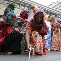 Former Filipino comfort women light candles during a protest in front of the Japanese Embassy in Manila on Friday. Filipino 'comfort women' call for Emperor's help in seeking redress