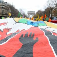 Standing up for the planet: Activists hold up a giant banner during a demonstration in Paris on Dec. 12. 2015 a 'tipping point' for climate change