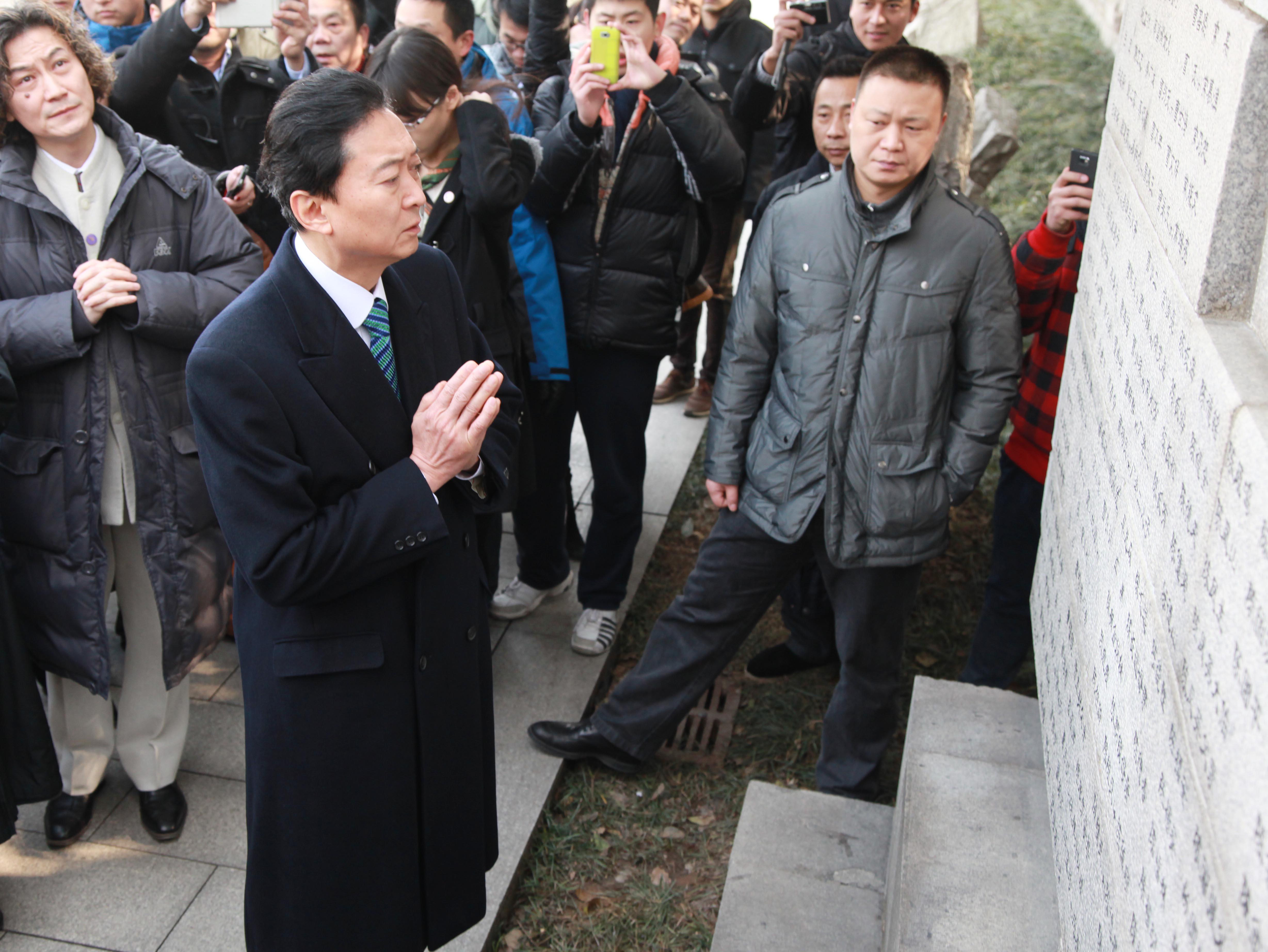 Sorrow: Hatoyama offers a prayer in front of a monument bearing the names of victims at the Nanjing Massacre Memorial Hall in 2013.