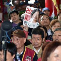 A fan of Tsai Ing-wen, presidential candidate for Taiwan's main opposition Democratic Progressive Party, holds a magazine cover depicting her as supporters wait for Tsai to arrive at a rally in Taipei on Jan. 6. Views from Taipei: Should Taiwan declare full independence in the event of a DPP win?