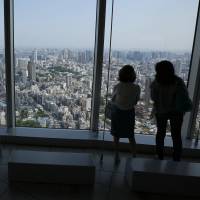 Tourists take in the view of Tokyo from the Roppongi Hills Mori Tower in Tokyo on May 9, 2014. Japan is gearing up for an influx of visitors ahead of the 2020 Games. Japan's 2020 problem: life after the Olympics