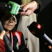 Falak al Hourani, 7, who has a rare form of eye cancer, stands beside her mother, Yasmina, as they are interviewed by journalists upon their arrival at Rome's Fiumicino international airport Thursday. Syrian girl, 7, with rare cancer first to use new Italy humanitarian corridor