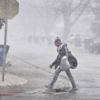 A woman walks into the wind as snow begins to fall and visibility quickly drops Wednesday in Bourbonnais, Illinois. A powerful storm moving through parts of the Midwest on Wednesday could dump more than a foot of snow in places. Blustery blizzard scrubs 1,000 Chicago flights