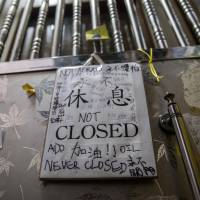 A closed sign with words of support from visitors written on it is displayed outside the security gate of Causeway Bay Books in Hong Kong on Feb. 1. China faces diplomatic crisis over missing Hong Kong booksellers