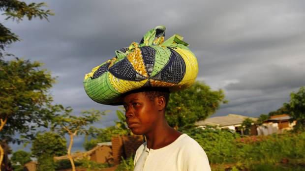 Malawian subsistence farmer Louise Abele carries corn she bought to feed her family near Lilongwe on Jan. 31. In southern Africa, an illusion built on aid heralds hunger