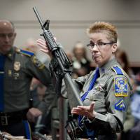 Firearms training unit Detective Barbara J. Mattson, of the Connecticut State Police, holds up a Bushmaster AR-15 rifle, the same make and model of gun used by Adam Lanza in the Sandy Hook School shooting, during a hearing of a legislative subcommittee, at the Legislative Office Building in Hartford, Connecticut, in January 2013. Gun maker seeks dismissal of lawsuit over Newtown shootings