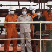 Some of the rescued crew members of the hijacked Panama-flagged Maximus stand for the media in Lagos Monday. Nigerian navy kills pirate, storms, rescues thrice-hijacked oil tanker