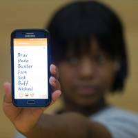 A student from East London Youth Dance Company holds a phone displaying slang that she uses in daily life at the University of East London on Feb. 13. Sick, bad, wicked: London's colorful slang on the rise among youths