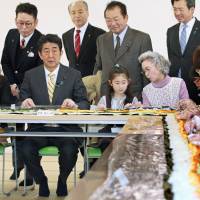 Prime Minister Shinzo Abe makes rolled sushi with residents of a public housing facility for victims of the 2011 Great East Japan Earthquake in Ishinomaki, Miyagi Prefecture, on Sunday. Spate of scandals, gaffes push Abe Cabinet support rate down 7 points to 46.7%