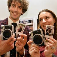 This August 2013 Tokyo photo shows camera maker Fujiflm's instant camera, the Instax mini 90 Neo Classic, which can make card-sized prints instantly. Camera makers struggle to stay atop smartphone wave