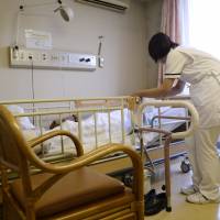 A nurse tends to a patient at a Tokyo hospital in September 2014. Japan spends more than ¥40 trillion a year on health care, the details of which are decided every two years by a panel of experts. Competing interests converge on health care price-setting panel