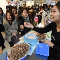 A vendor offers chocolates to customers at a department store in Tokyo on Feb. 9. Give me chocolate: Japan's growing obsession with the 'food of the gods'