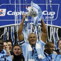 Manchester City captain Vincent Kompany raises the trophy after his team's victory over Liverpool in the League Cup final on Sunday at Wembley Stadium in London. Man City lifts League Cup