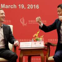 Facebook founder and CEO Mark Zuckerberg speaks with Alibaba Group Chairman Jack Ma during the China Development Forum in Beijing on Saturday. Executives pay top dollar for audience with China's leaders